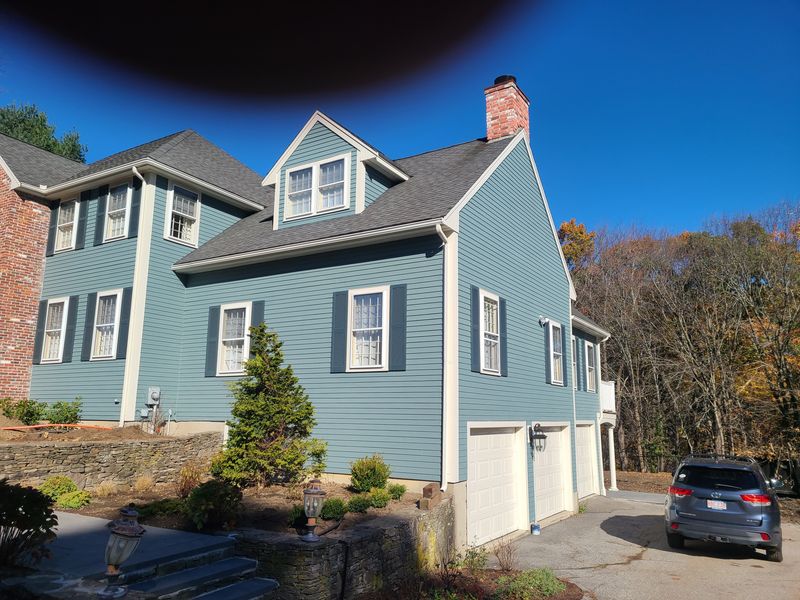 Blue-grey colonial and garage after full exterior repaint