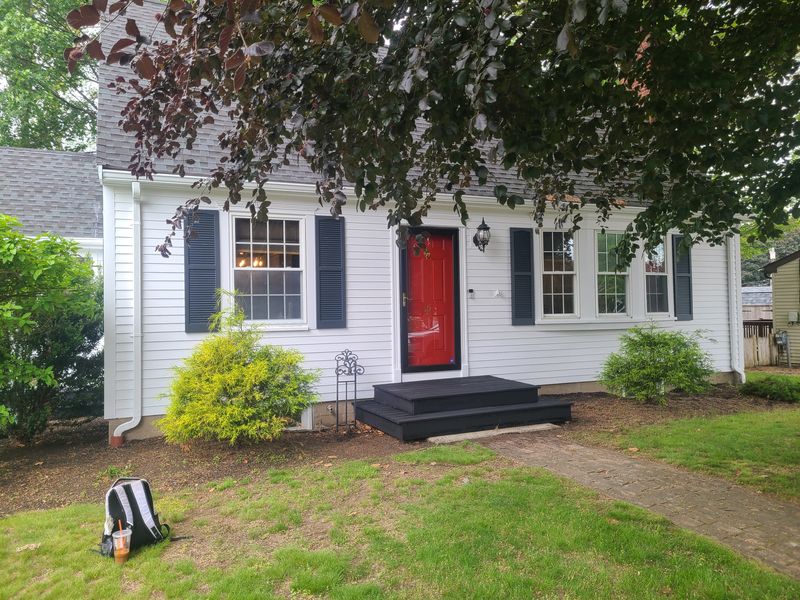 Cape exterior finished with black shutters and fresh trim