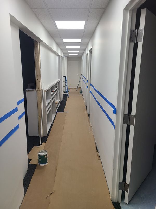 Commercial office corridor masked and prepared for painting