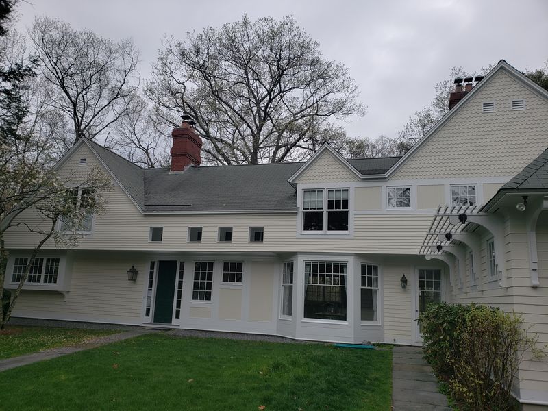 Scalloped shingle gables and trim detail on a large home