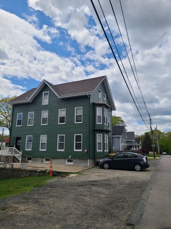 Three-family exterior finished in green with white trim