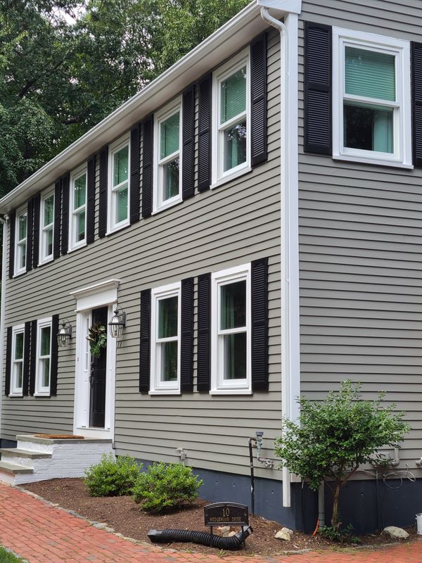 Two-family exterior finished in grey with black shutters