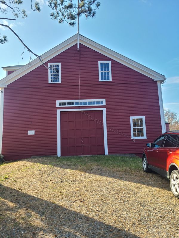 Historic farm barn repainted in traditional red with white trim
