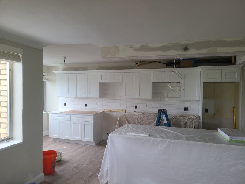 Kitchen cabinetry masked and protected during finishing