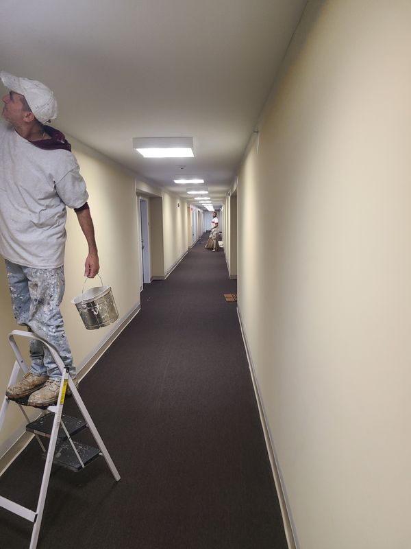 Painter working a corridor in an occupied building