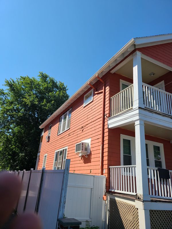 Red three-family with white porch stacks after repainting