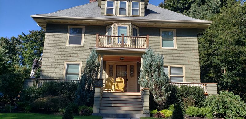 Sage-green Foursquare with turned-baluster balcony after repainting