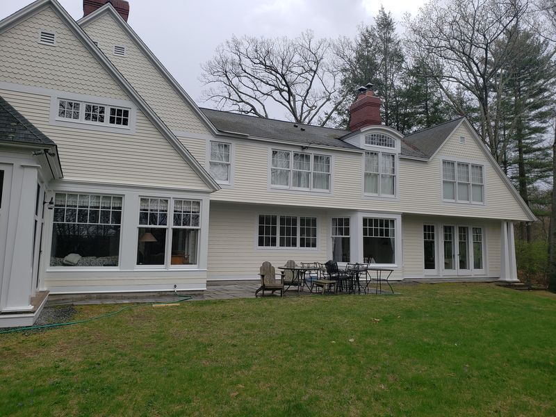 Rear elevation of a large shingle-style home after painting