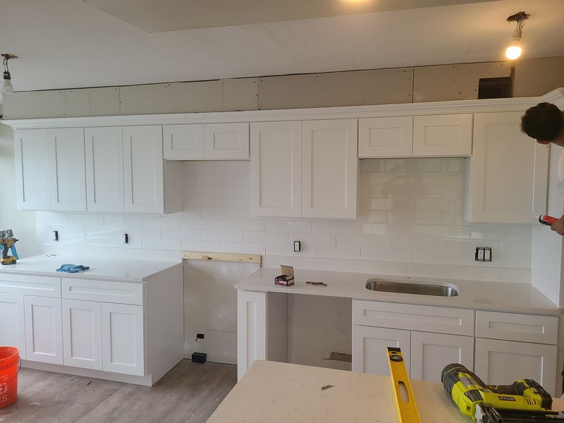 Kitchen with white cabinetry after refinishing