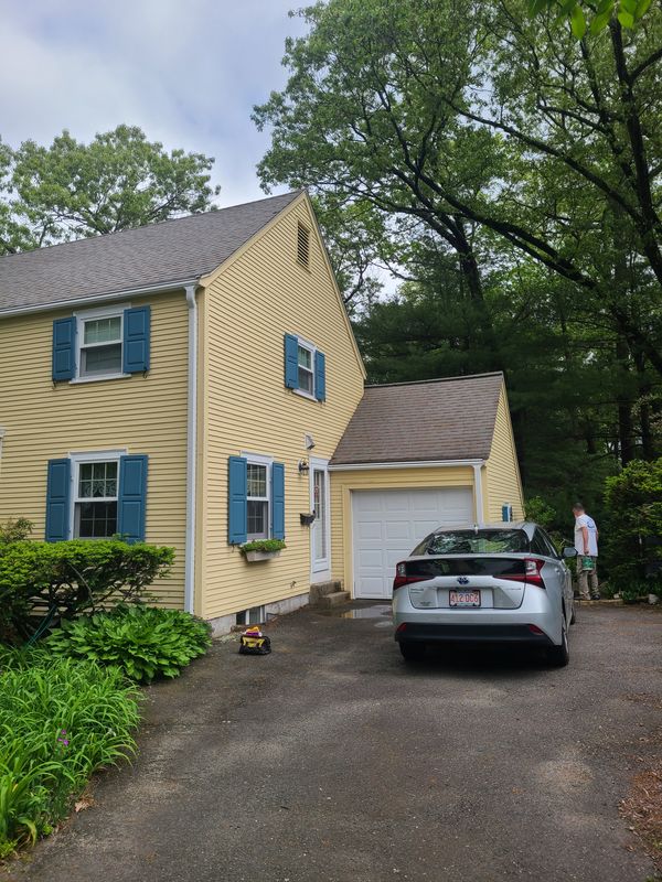 Yellow colonial with blue shutters after exterior repainting